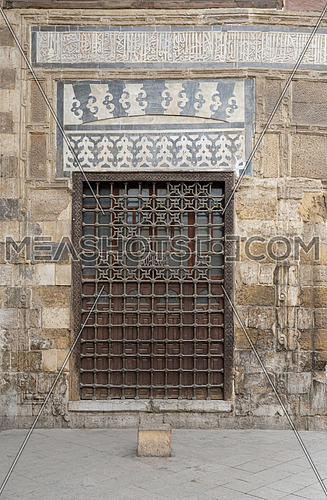 Wooden window with decorated iron grid over stone bricks wall at Madrasa and Mausoleum of As-Saleh Nagm Ad-Din Ayyub, Medieval Cairo, Egypt