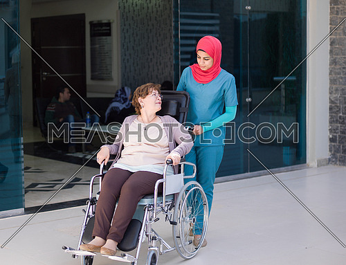 older sick woman in wheelchair with young nurse at  hospital