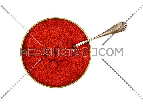Close up one bronze metal bowl full of red chili pepper or paprika powder with spoon isolated on white background, elevated top view, directly above