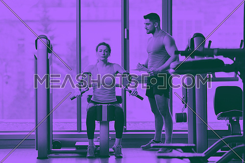Gym woman exercising with her personal trainer duo tone