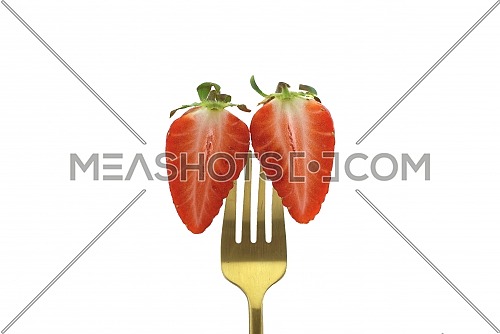 Two halves of a half-cut strawberry pinned on a golden fork isolated on a white background