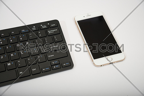 black computer keyboard and mobile phone