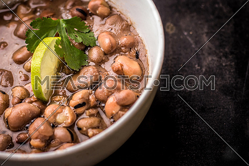 Foul Mesdames egyptian breakfast in a white bowl isolated on a black background