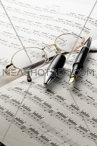 music charts with glasses and pen on top