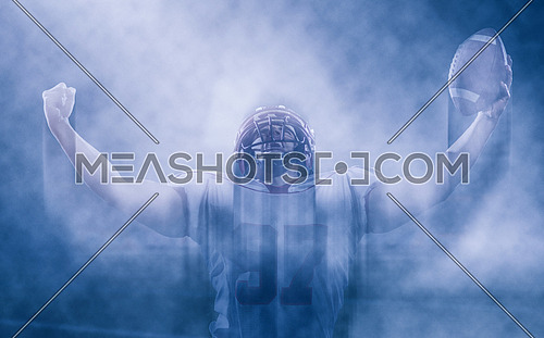 american football player celebrating after scoring a touchdown on field at night with smoke effect around