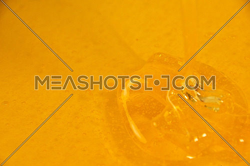 Close up background of pouring fresh thick fluid acacia honey in bowl, high angle view