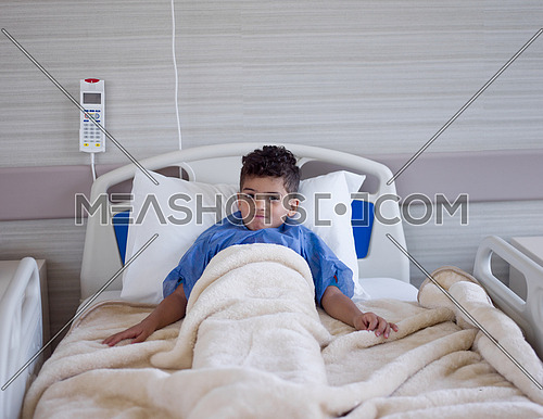 young boy patient lies in a hospital bed