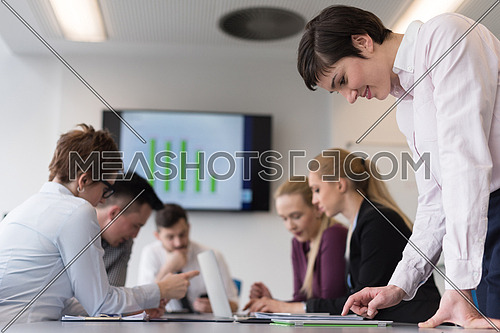 young businesswoman in casual hipster clothes working on tablet computer at modern startup business office, people group working and brainstorming in background