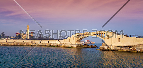 Panoramic view of bridge in the sea at Montazah park with the Royal palace in the far distance with calm sea at sunrise time, Alexandria, Egypt