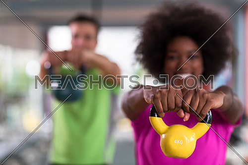 healthy couple  workout with weights lifting  dumbbels at  crossfit gym african  american woman with afro hairstyle