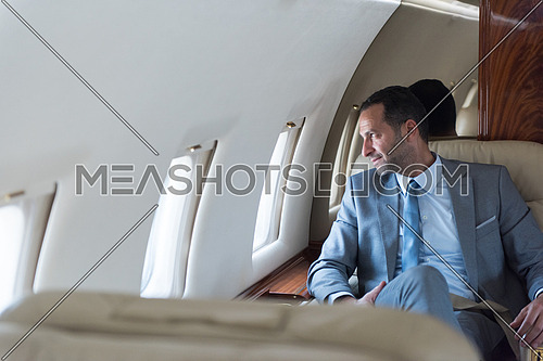 Portrait of a young middle eastern successful businessman who enjoys sitting in private jet