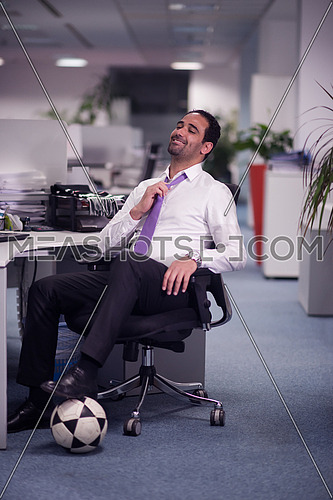 business man at office workplace with  soccer ball under table