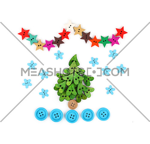 Close up Christmas tree decoration collage of colorful multicolor handmade wooden sewing buttons on white background, elevated top view, directly above