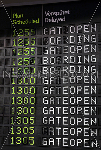 Flight information panel desk at airport, with time, boarding and gate open messages, close up, low angle view