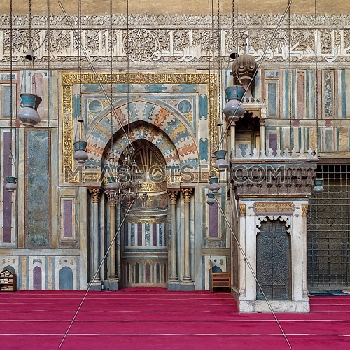 Colorful decorated marble wall with engraved Mihrab (niche) and wooden Minbar (Platform) at the Mosque and Madrassa (School) of Sultan Hassan, Cairo, Egypt