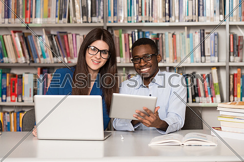 In The Library - Handsome Two College Students With Laptop And Books Working In A High School - University Library - Shallow Depth Of Field