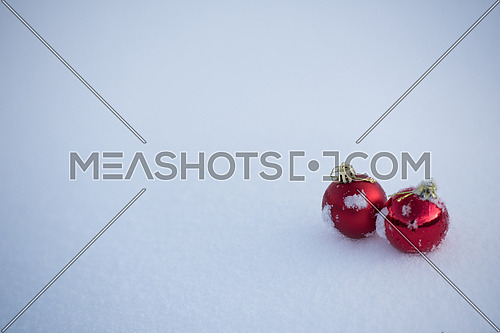 christmas red balls decoration in fresh snow background on beautiful sunny winter day