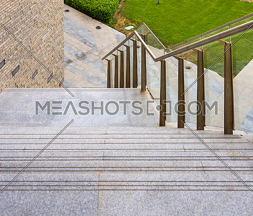 Marble staircase and glass handrail leading to street from contemporary city office building