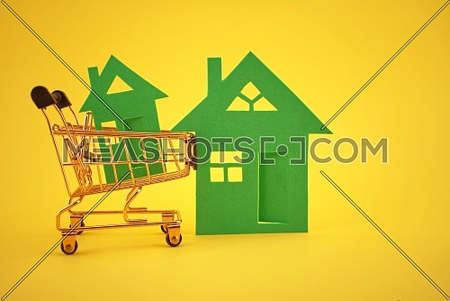 Buy real estate concept with house and shopping cart over yellow background and free copy space for text