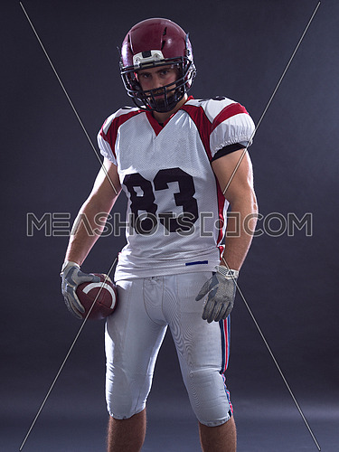 Portrait of a strong muscular American Football Player isolated on gray