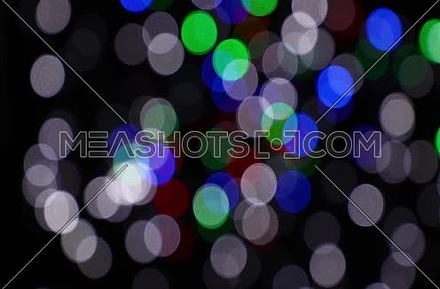 Colorful multicolor festive Christmas circular bokeh over dark, white, blue, green and red lights slow moving trembling and shaking