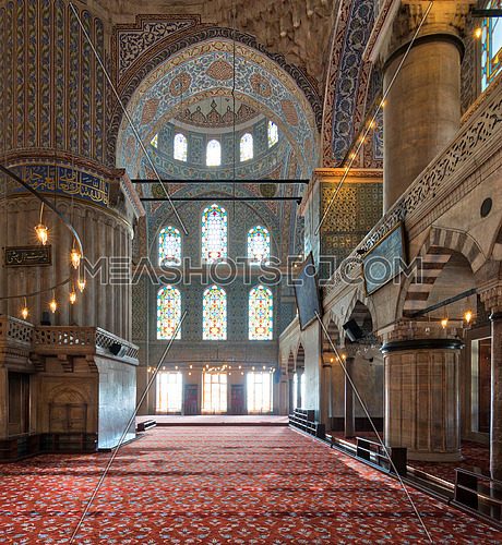 Interior of Sultan Ahmed Mosque (Blue Mosque), with a huge pillars, arches, and colored stained glass windows, Istanbul, Turkey