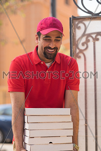happy middle eastern pizza delivery guy with a smile delivered a delicious pizza