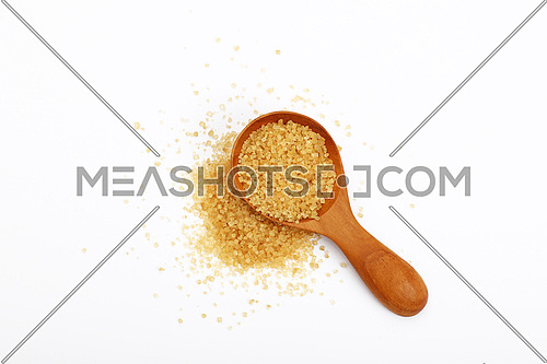 Wooden scoop spoon of brown cane sugar with pinch of sugar spilled around isolated on white background, top view