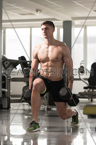 Healthy Fitness Man Working Out Legs With Dumbbells In A Gym - Front Squat Exercise