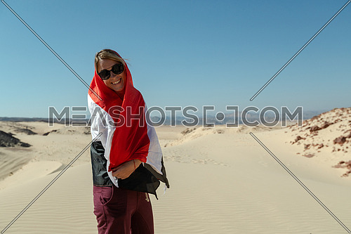 Female tourists spreading Egyptian flag while exploring Sinai Trail from Ain Hodouda at day.