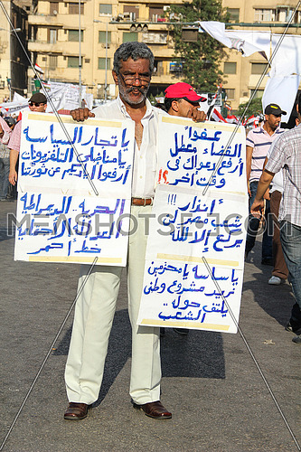 a man holding signs in tahrir square