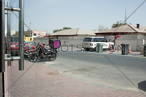 A delivery motorcycle parked infront of a restaurant
