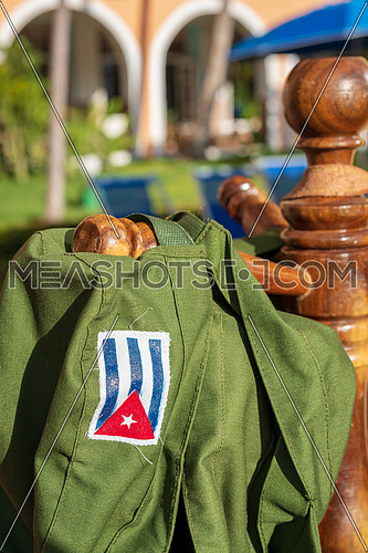Green military hat with printed Cuban flag hanging in the sun, symbol of the Cuban revolution.