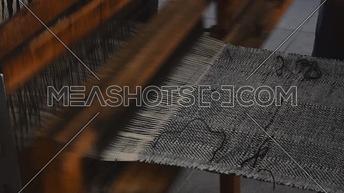 Close up man hands weave canvas with antique loom handweave machine, side view
