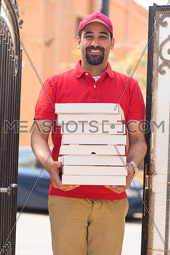 happy middle eastern pizza delivery guy with a smile delivered a delicious pizza