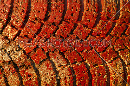 Old vivid red painted truck wheel tire tread grunge background texture close up