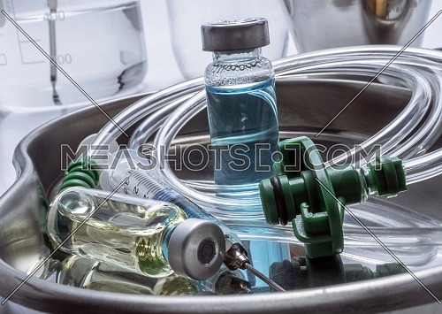 Multiple vial and syringe in a tray metal, conceptual image