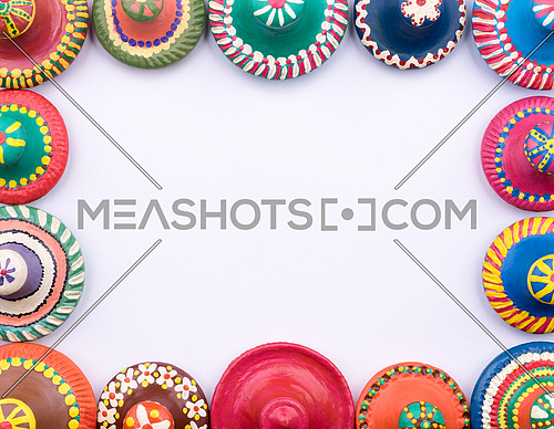 Frame of painted colorful pottery lids on white background