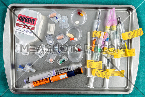 Containers with medication next to insulin needles prepared in hospital, conceptual image, horizontal composition