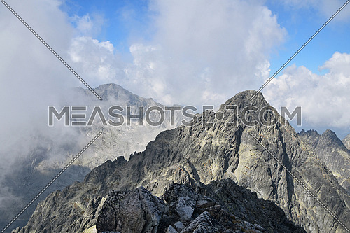 Landscape of summer rocky mountain ridge in foggy clouds, High Tatra mountains