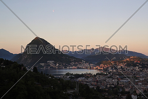 First lights of dawn on the bay of Lugano on lake Ceresio, Ticino, Switzerland