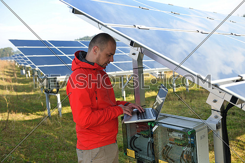 business man  engineer using laptop at solar panels plant eco energy field  in background