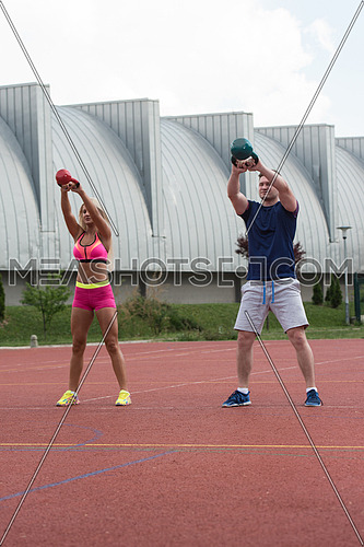A Group Of Young People In Aerobics Class Doing A Kettle Bell Exercise Outdoor