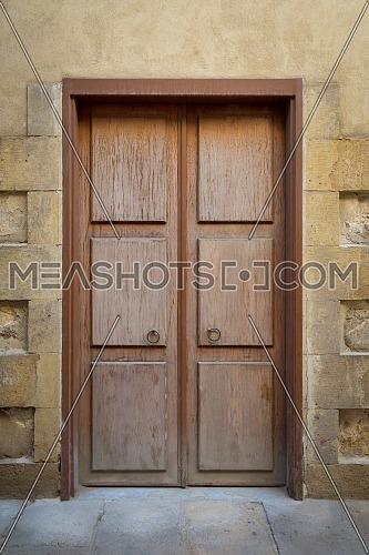Grunge wooden aged door on grunge stone bricks wall, Medieval Cairo, Egypt