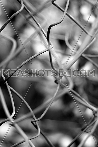 a wire fence blurred with an out of focus subject in the background