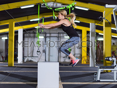 young athletic woman training  jumping on fit box at crossfitness gym