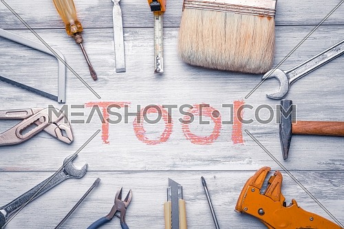 Set of work tool on rustic wooden background with written 