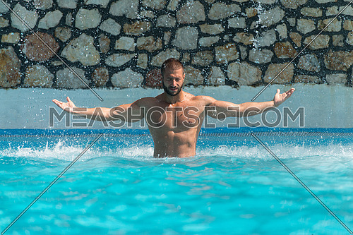 Man In A Public Swimming Pool Standing Under A Water