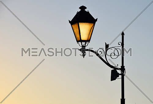 Street antique style lamp post with effect of shine from low light of sunset