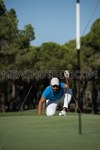 golf player aiming shot with club on course at beautiful sunny day